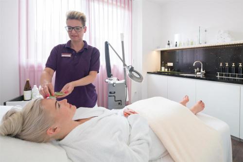 a man standing next to a patient in a hospital room at Best Western Plus Kurhotel an der Obermaintherme in Bad Staffelstein