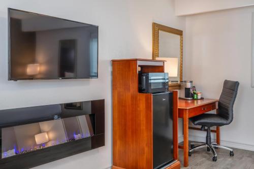a hotel room with a desk and a tv and a deskictericter at Comfort Inn & Suites Thousand Islands Harbour District in Gananoque