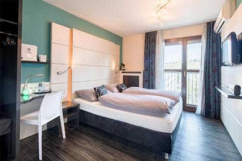 a bedroom with a bed and a desk and a window at Best Western Hotel Würzburg-Süd in Würzburg
