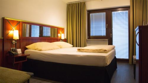 a hotel room with two beds and a window at Best Western Hotel Würzburg-Süd in Würzburg