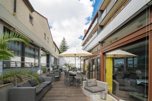 an outdoor patio with chairs and tables and umbrellas at Best Western Hotel Würzburg-Süd in Würzburg