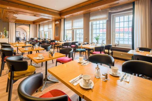 a restaurant with wooden tables and chairs at Best Western Hotel Würzburg-Süd in Würzburg