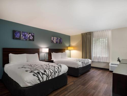 a hotel room with two beds and a window at Sleep Inn Savannah Midtown in Savannah