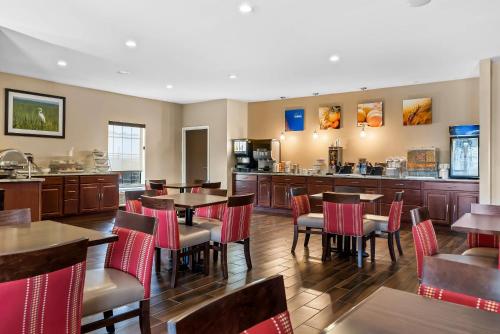 a restaurant with tables and chairs and a bar at Comfort Suites near Camp Lejeune in Jacksonville