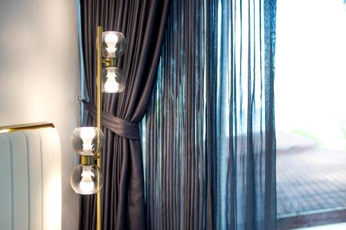 a room with a curtain and a window with lights at Nariya Bayfront Phuket in Ban Bang Chak