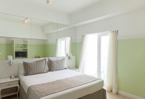 a bedroom with a large white bed and a window at Olinda Rio Hotel in Rio de Janeiro
