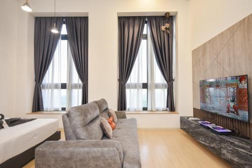 a living room with a couch and a tv at Sunway Grid Loft Suite by Nest Home【Olympic Size Pool】 in Kampong Pendas