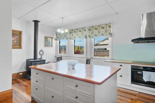 a kitchen with white cabinets and a large island at Franklin Lodge Huon Valley Iris Room in Franklin