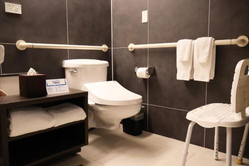 a bathroom with a toilet and a sink and towels at Hilton Guam Resort & Spa in Tumon