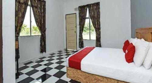 a bedroom with a bed and a checkered floor at OYO 90507 Chalet Sumayyah in Melaka