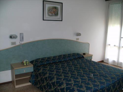 a bedroom with a bed with a blue comforter at Hotel Moby Dick in Rimini