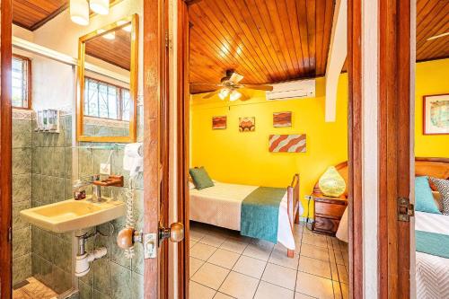 a bathroom with a bed and a shower and a sink at Villa Jaco Sol in Jacó