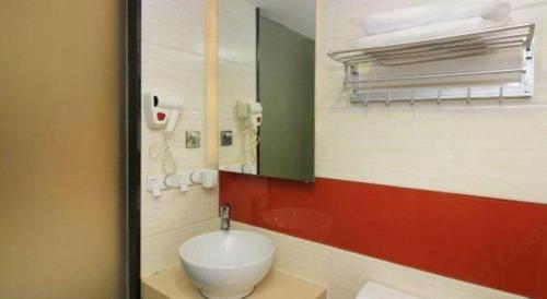 a bathroom with a white sink and a mirror at 7 Days Premium Zhuhai Gongbei Light Railway Branch in Zhuhai