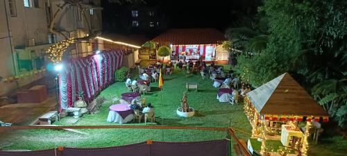 a group of people sitting on the grass at night at The Palmyrah Tenements in Mysore