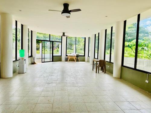 an empty room with windows and a ceiling fan at BossBabe Nacpan Beach House in El Nido