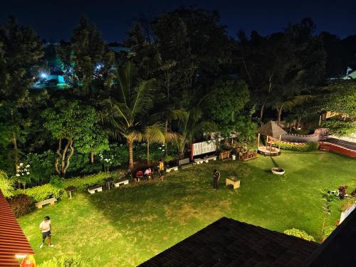a group of people standing in a yard at night at The Palmyrah Tenements in Mysore