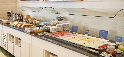 a buffet line with many different types of food at NH Valencia Center in Valencia