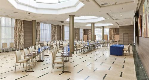 a large room with tables and chairs and windows at NH Valencia Center in Valencia