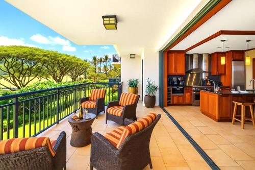 a patio with chairs and a kitchen with a balcony at KBM Resorts FREE CAR Beach Villas at Ko Olina BVK-B-308 Beachfront Villa in Kapolei