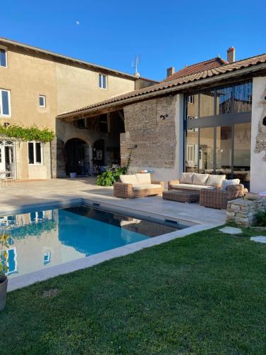 une cour arrière avec une piscine et une maison dans l'établissement Notre maison de famille, à Montmerle Sur Saône