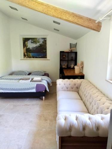 un salon avec un canapé et un lit dans l'établissement Villa Provençale - Rognes campagne d'Aix en Provence, à Rognes