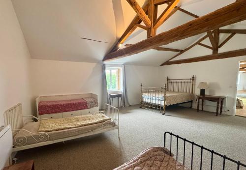 une chambre avec deux lits, une table et une fenêtre dans l'établissement Notre maison de famille, à Montmerle Sur Saône