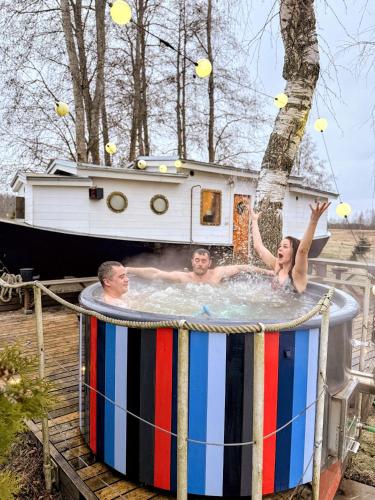 a group of people in a hot tub with a boat at Cozy little house with sauna on a fishing boat in Pärnu