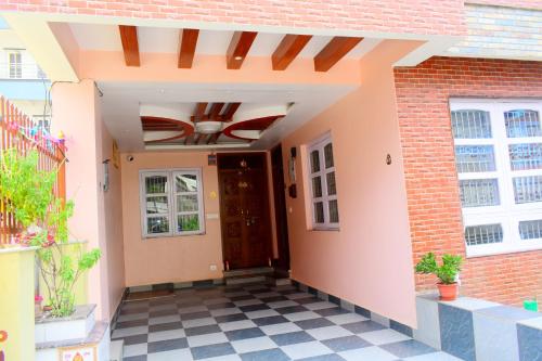 a front door of a house with a checkered floor at The Pahuna Apartment in Bālāju