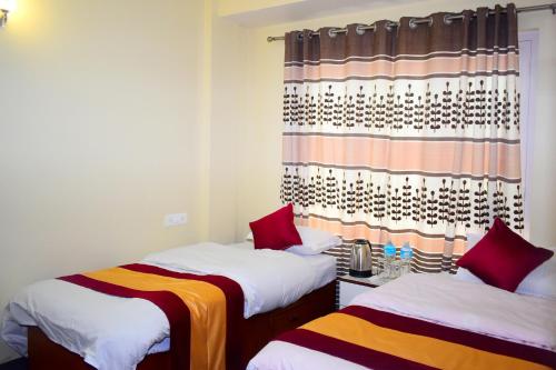 a room with two beds and a curtain at The Pahuna Apartment in Bālāju