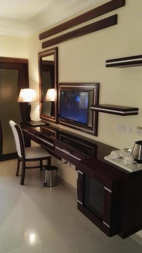 a room with a desk with a tv and a mirror at P Quattro Relax Hotel in Wadi Musa