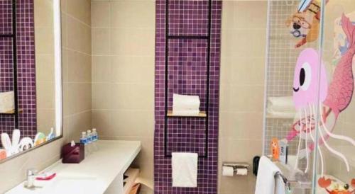 a bathroom with a purple shower curtain and a sink at Q Hotel Shanghai Pudong in Shanghai