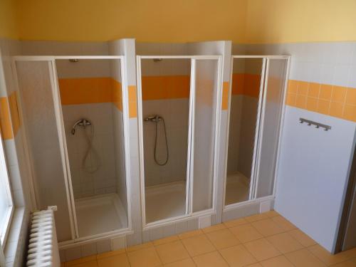 uma casa de banho com três cabinas de duche num quarto em Hostel Bernarda Bolzana em Tábor