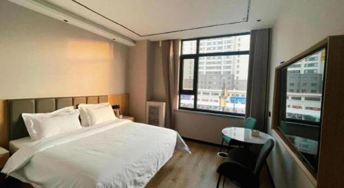 a bedroom with a white bed and a window at GreenTree Inn Datong YundinGYAyuan Express Hotel in Datong
