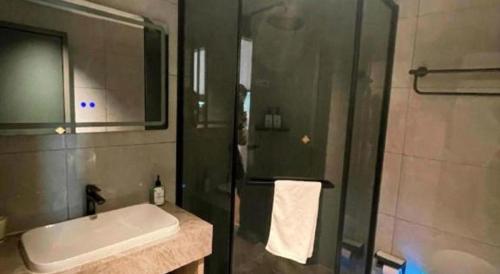 a bathroom with a shower and a sink and a shower at GreenTree Inn Datong YundinGYAyuan Express Hotel in Datong