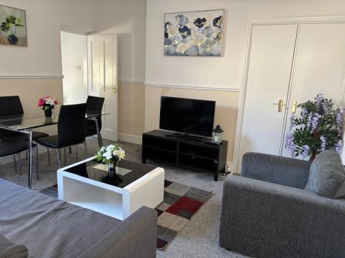 a living room with a couch and a tv at Zinoc Delight, free parking, at City centre, close to the sea & lovely places in Blythe