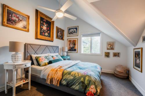 a bedroom with a bed and pictures on the wall at Lucille with a view in Warburton