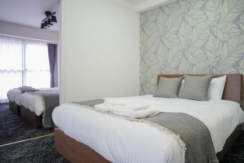 a bedroom with two beds with towels on them at MP STYLE SAPPORO-37 in Minami-jūichijō