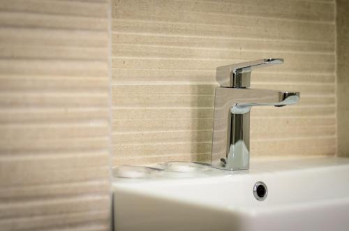 a bathroom sink with a faucet on top of it at Villa Kudelik - Stone Story in Trogir