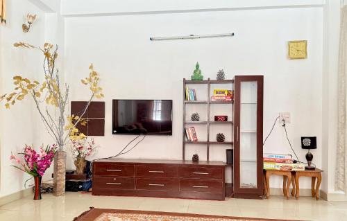 Una sala de estar con un televisor en la pared. en The Solan Greens, en Solan