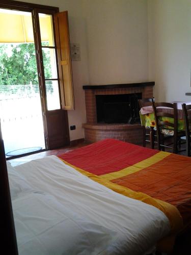 a large bed in a room with a fireplace at il Chiassetto Agriturismo No Kids in Cascina