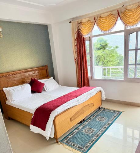 a bedroom with a bed with a large window at The Solan Greens in Solan