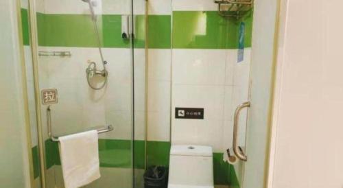 a green and white bathroom with a toilet and a shower at 7 Days Inn Changchun Zhengyang Street Changchun Park Branch in Changchun