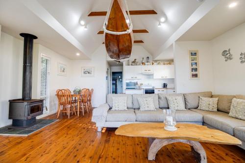 a living room with a couch and a table at Beach Shack on the Lagoon in Berrara