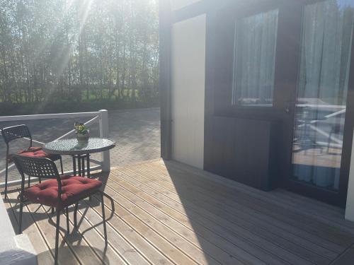 a patio with a table and chairs on a deck at Vila Kalniškiai in Varkaliai