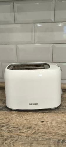 a white toaster sitting on a wooden floor at Apartmán Levandule in Mařenice