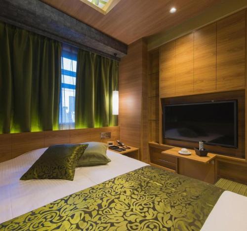 a bedroom with a bed and a flat screen tv at Hotel Ann Tsukiji in Tokyo
