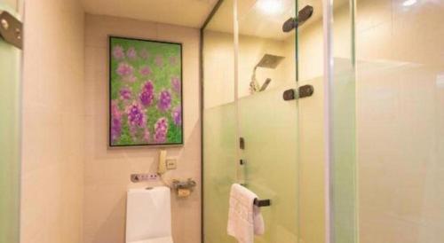 a bathroom with a shower and a painting on the wall at Lavande Hotels Suzhou Railway Station in Suzhou