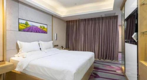a bedroom with a large white bed and a window at Lavande Hotels Suzhou Railway Station in Suzhou
