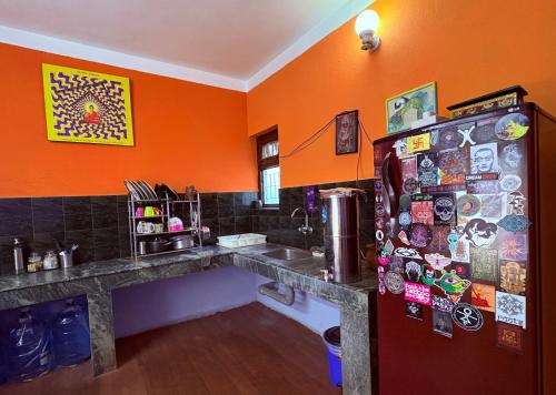 una cucina con pareti arancioni e un frigorifero con magneti di DRAKON NEST HOMESTAY a Kathmandu