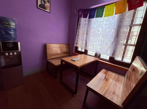 a room with two wooden tables and a window at DRAKON NEST HOMESTAY in Kathmandu